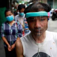 Migrant workers from Myanmar who lost their jobs line up for free foods from volunteers following the coronavirus disease (COVID-19) outbreak in Bangkok, Thailand April 23, 2020. | REUTERS/Soe Zeya Tun