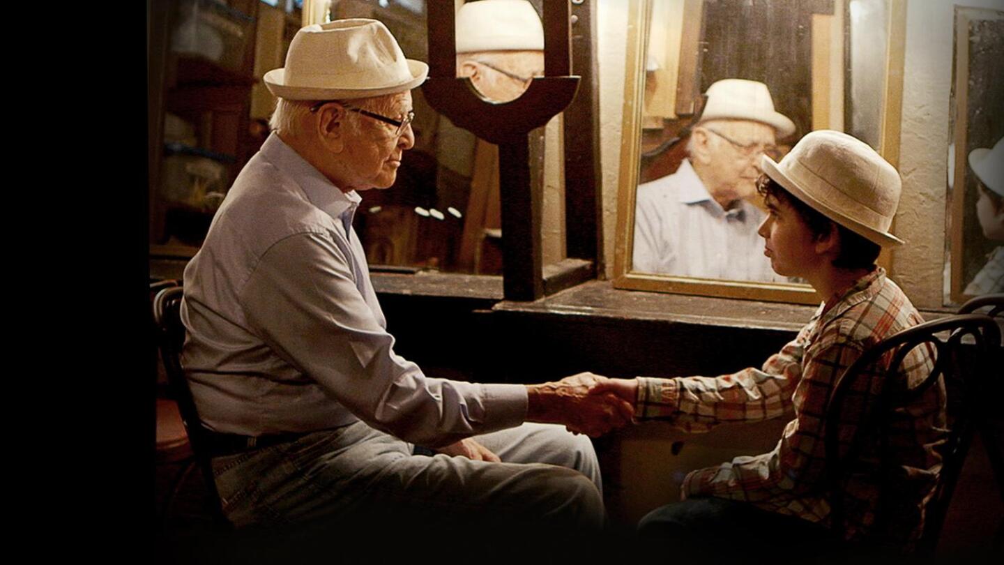 Norman Lear grasps a young person's hand.