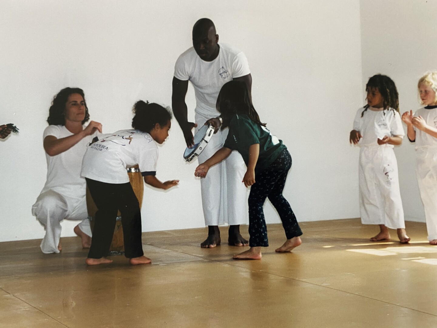Lukaza and Kenja learn rituals of entering the capoeira roda with Author and Mestre Amen Santo at Brasil Brasil Cultural Center.