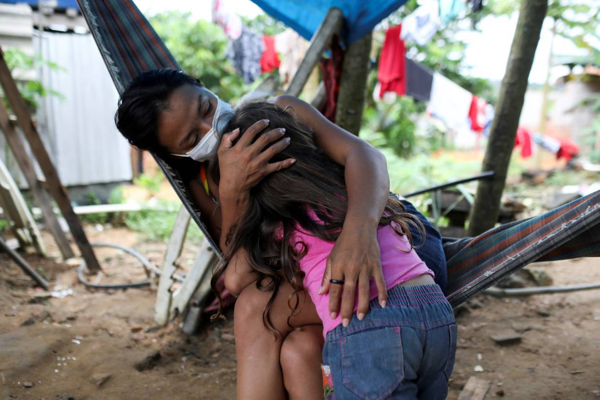 Vanderlecia Ortega dos Santos, 32, a nurse who has volunteered to provide the only frontline care protecting her indigenous community of 700 families from the COVID-19 outbreak, embraces her niece Maria Eduarda Ribeiro Ortega, 4.