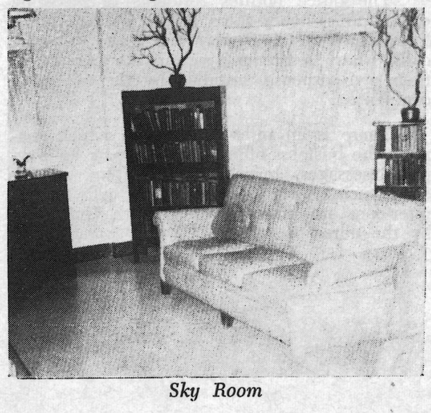 A black and white photo of a lounge at the Woman's Christian Temperance Union Home. There is a large couch and a bookshelf topped with a decorative tree.