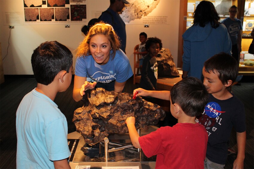 A volunteer talks to kids during the 2016 edition of UCLA's Exploring Your Universe outreach event. | UCLA Meteorite Collection