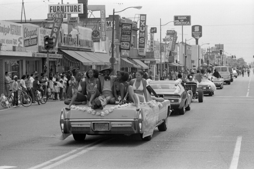 African American men and women in a parade of cars during Cinco de Mayo in Compton.