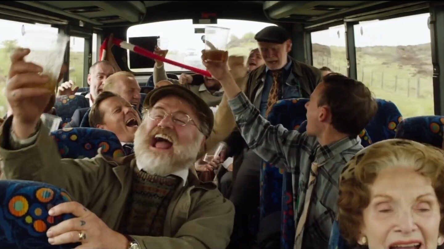 People in a crowded bus celebrate with a toast.