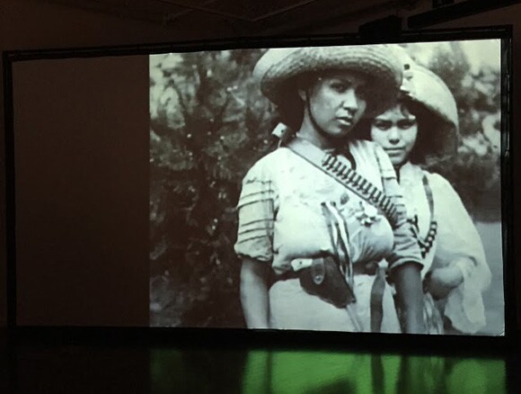 Installation view, Nao Bustamante, "Soldadera," 2015. Cinematic installation, 5 minute film, projected on a 16'x9' screen, on loop. | Photo: Nathalie Sánchez.