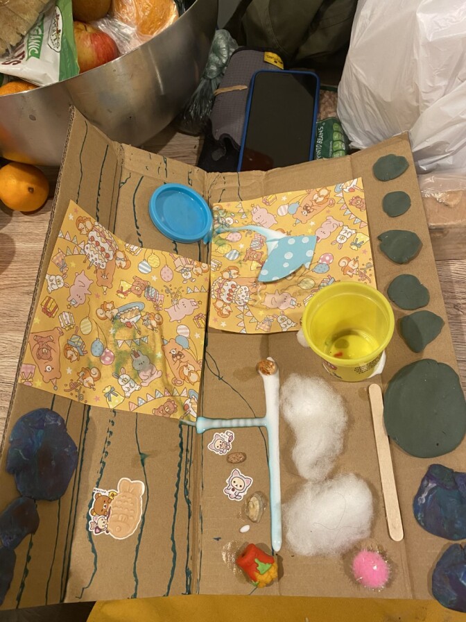 A piece of cardboard with everyday items like cotton, glue and Play-Doh.