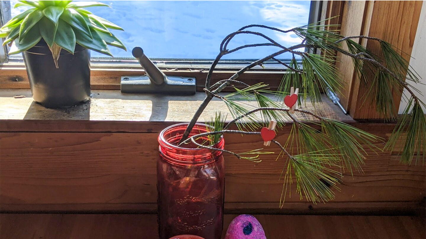a branch in a jar is filled with clothespins with hearts on them