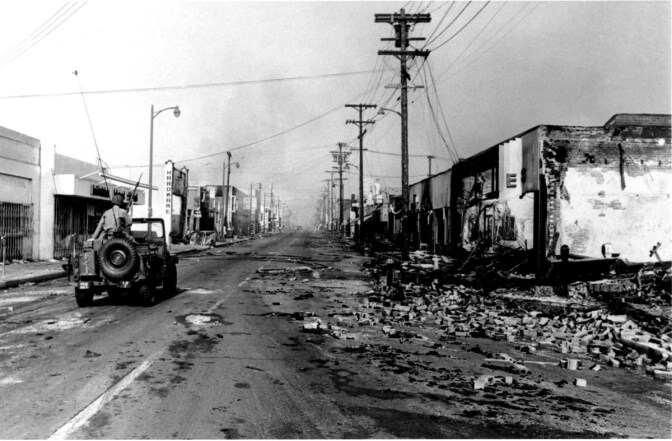 National guardsman in a jeep patrol a rubble-strewn street in the Watts neighborhood after a several-day long riot, Los Angeles, California, mid August, 1965.| PhotoQuest/Getty Images
