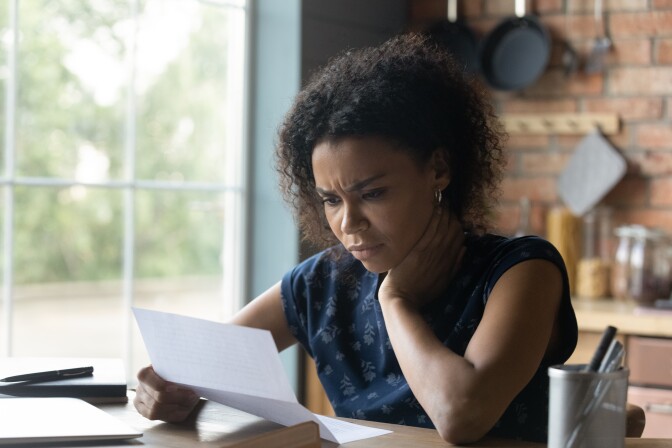 a Black homebuyer frowns in front of a denied application