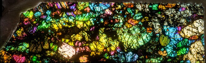 A thin, colorful section of a hot desert meteorite found in Africa.