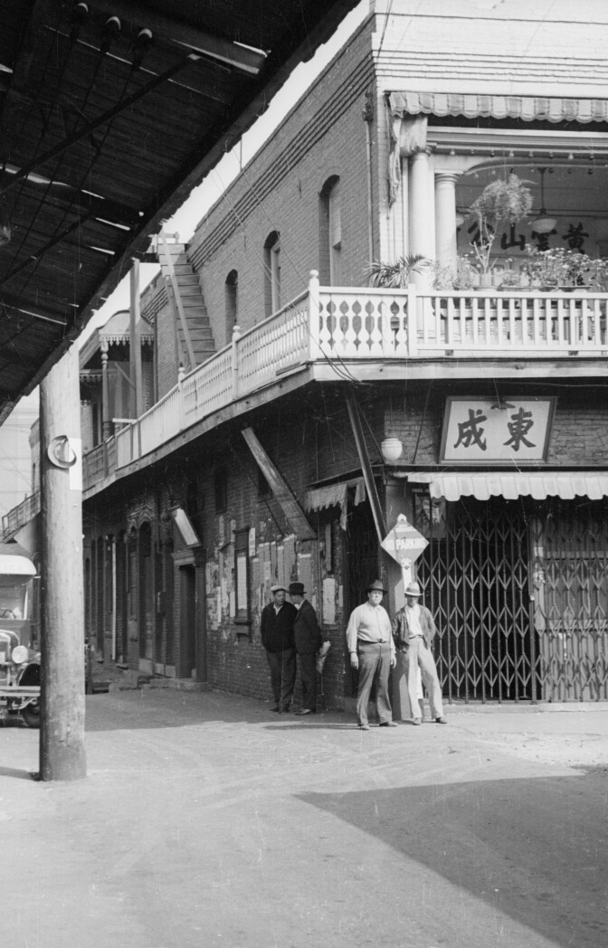 Men spending time outdoors with a sign that says "Cheng Dong" in Mandarin.