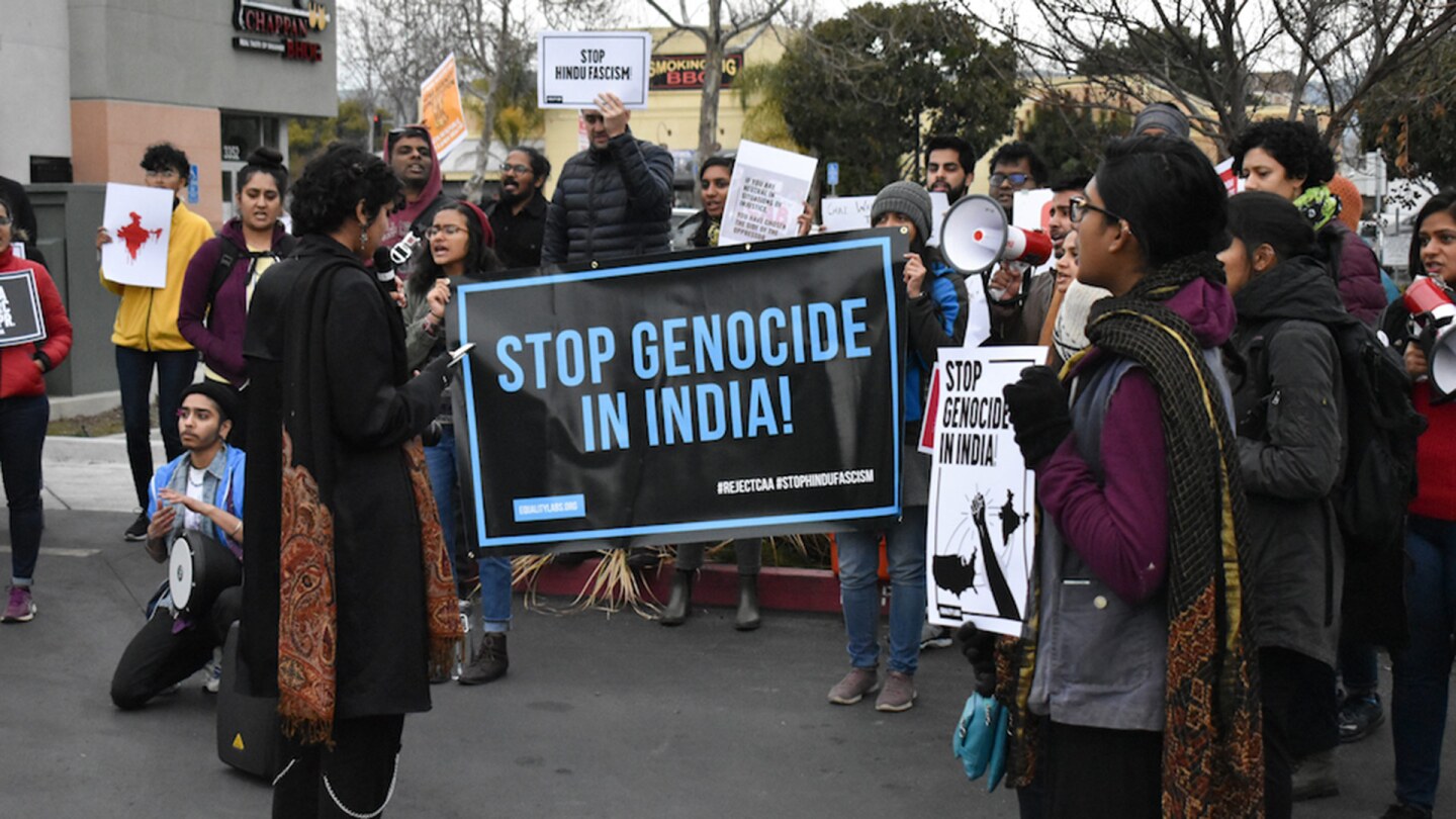 Demonstrators hold signs that read "Stop genocide in India"