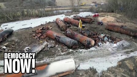 Scraps of damaged train cargo lie in a pit.