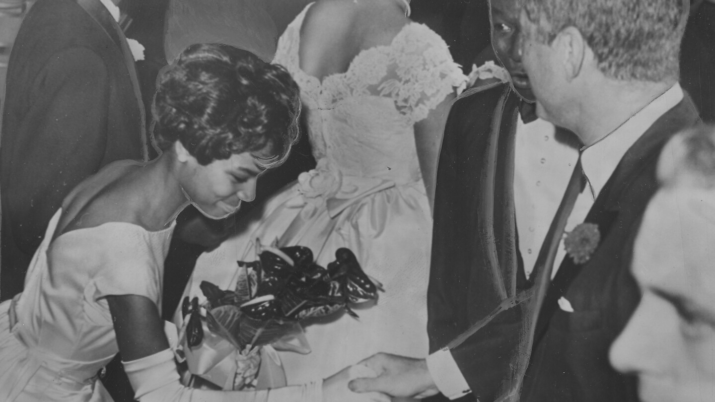 Nat King Cole And John F. Kennedy greet an African American debutante.