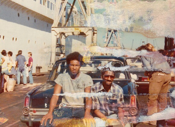 Two students pose by a taxi marked "White Only" in South Africa in 1975. | Denise Sheridan