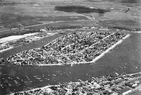 An archival photo of Balboa Island, an undeveloped Orange County mainland in the background.
