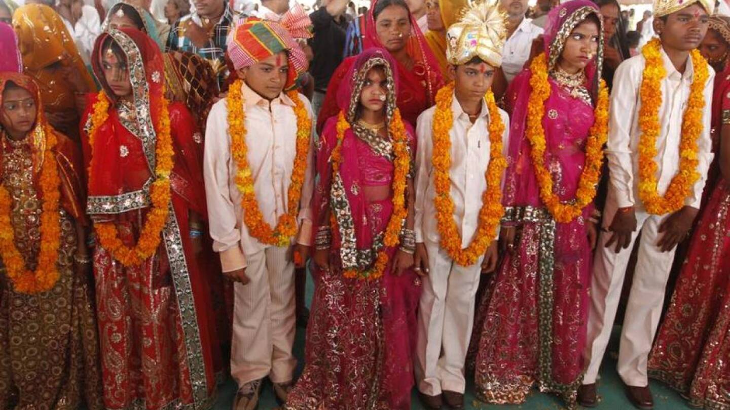 Boys and girls from the Saraniya community wearing garlands pose for pictures after their engagement ceremony at Vadia village in the western Indian state of Gujarat March 11, 2012. | REUTERS/Amit Dave