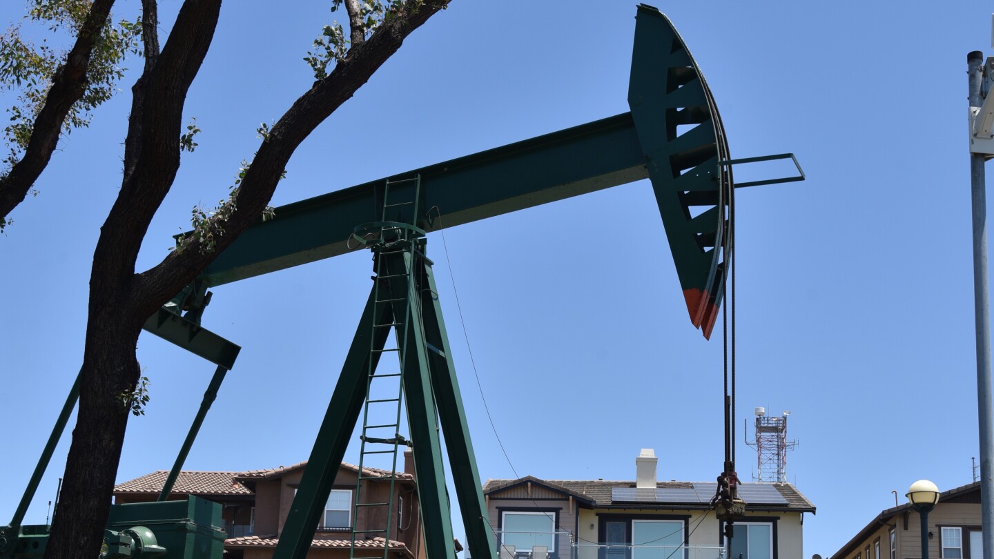 A oil pump jack pumps crude oil near homes in the Signal Hill neighborhood of L.A.