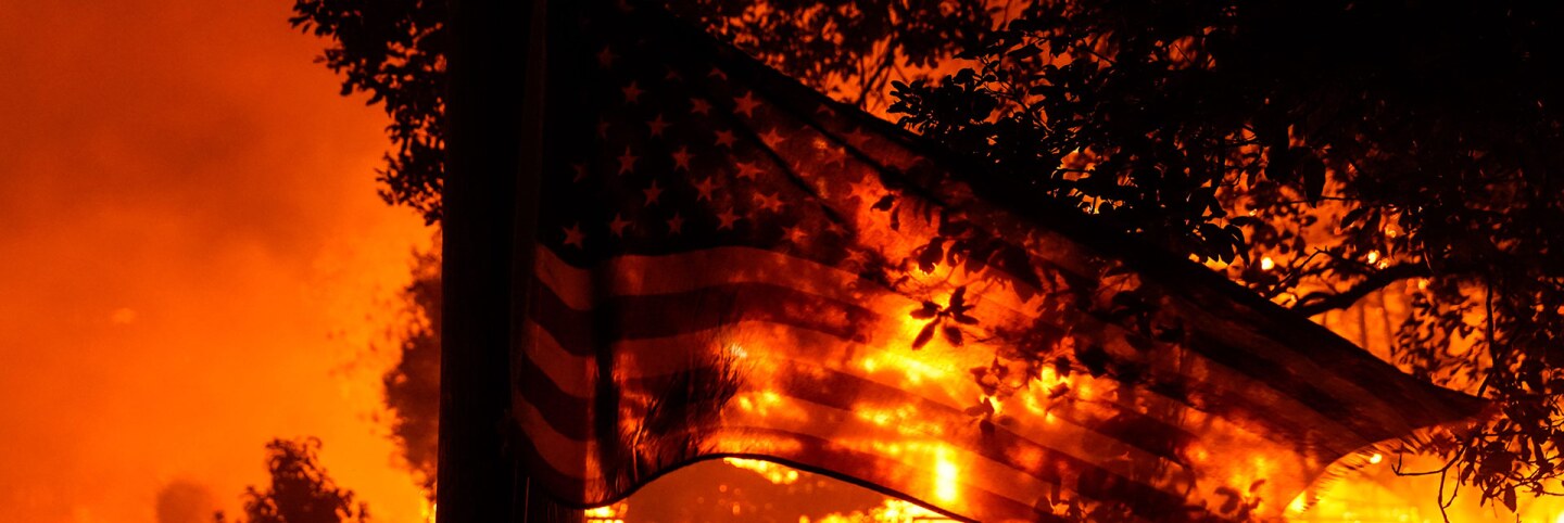 A U.S. Flag flaps in the wind as the Shady Fire impacts structures along CA-12 on Monday, Sept. 28, 2020 in Santa Rosa, California. | Kent Nishimura/Los Angeles Times via Getty Images