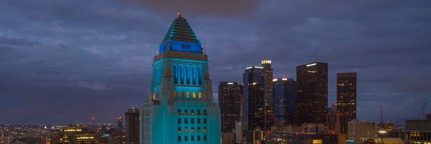An aerial view shows Los Angeles City Hall illuminated in blue as a tribute to healthcare workers responding to the coronavirus pandemic on April 18, 2020 in Los Angeles, California.