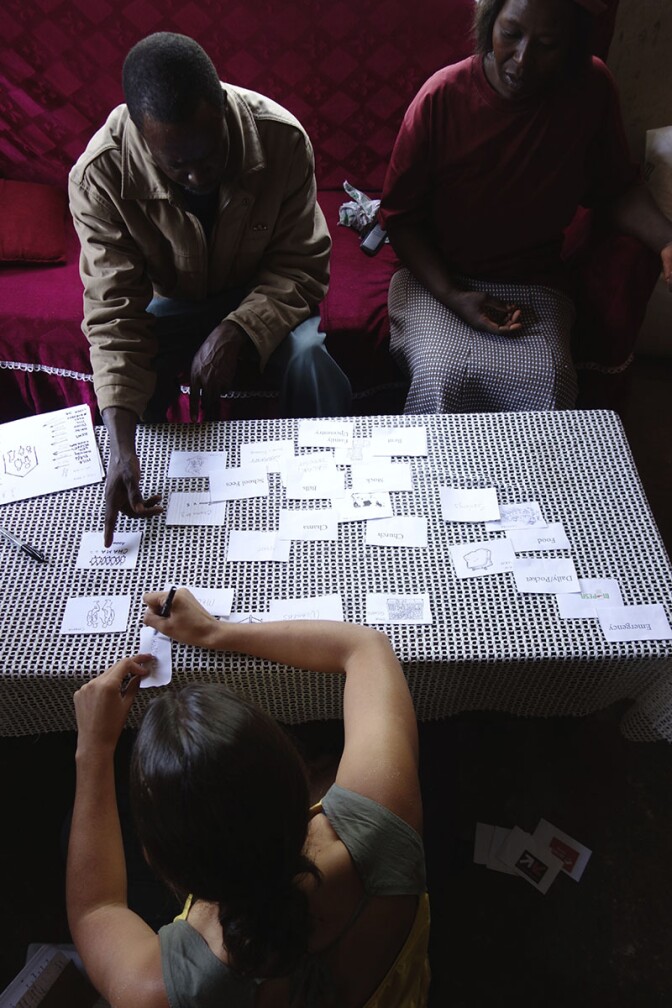 A farmer and his wife showing us how they move money among their accounts, assets and loans. | Danny Alexander, IDEO.org