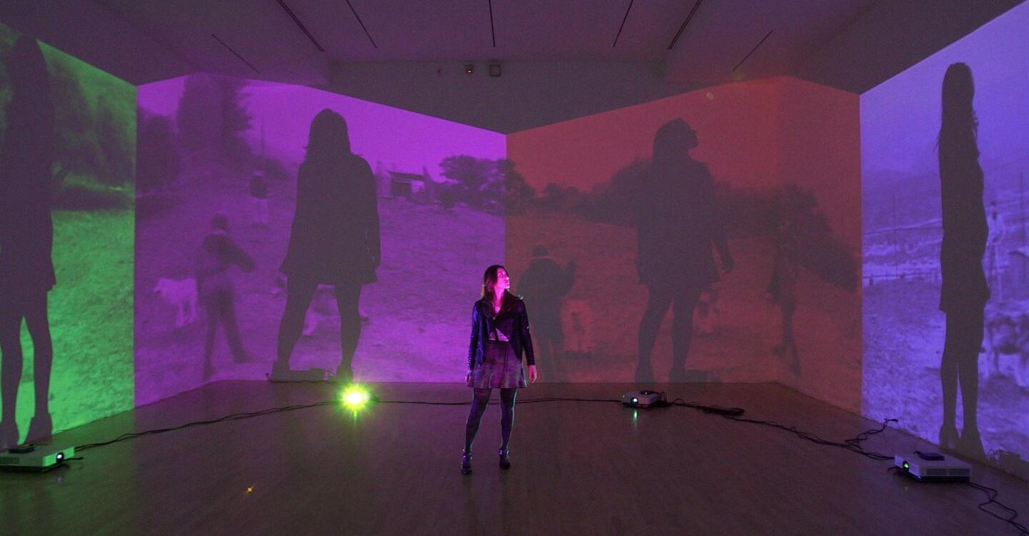 A woman standing in a room with her silhouette projected on four different screens. | "Art21: Los Angeles"
