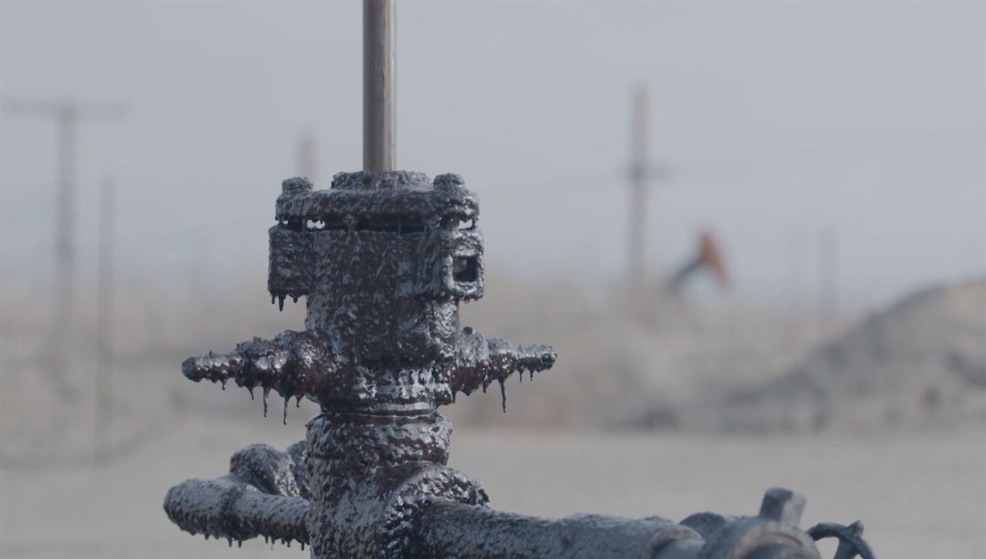 Closeup shot of residue on oil pump jack. | Still from "Earth Focus"