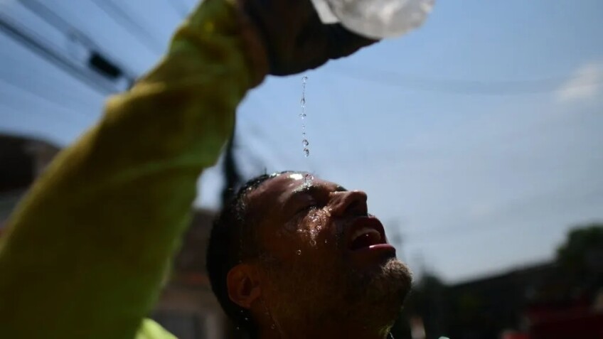 A man pours water on his face as he looks up