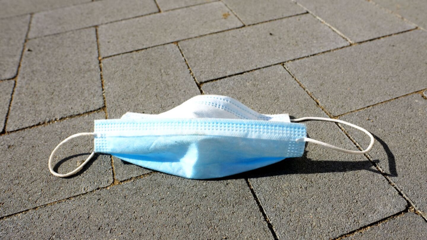 A protective face mask lies discarded on a pedestrian footpath on May 13, 2020 in Marina del Rey, California.