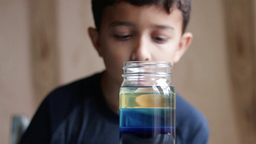 Child looks at jar