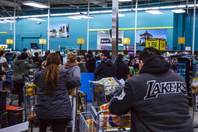 Shoppers wait in long lines to pay as stores across Los Angeles see an influx in customers. | Chava Sanchez/ LAist
