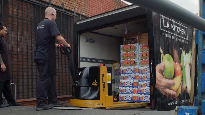 An L.A. Kitchen employee unloads pallets of produce rejected by the grocery store. | Still from "Broken Bread"