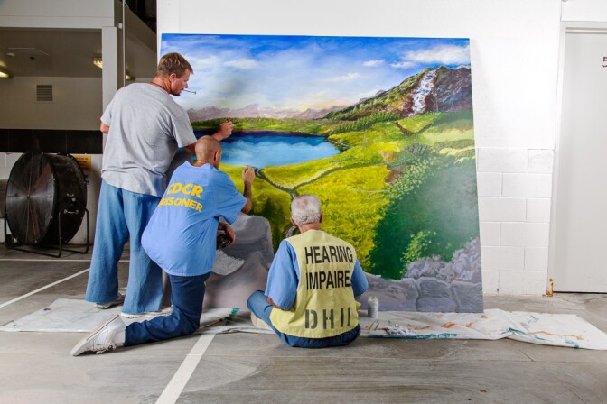 Prison inmates work on a mural as part of a Project PAINT art workshop at Richard J. Donovan Correctional Facility in San Diego.