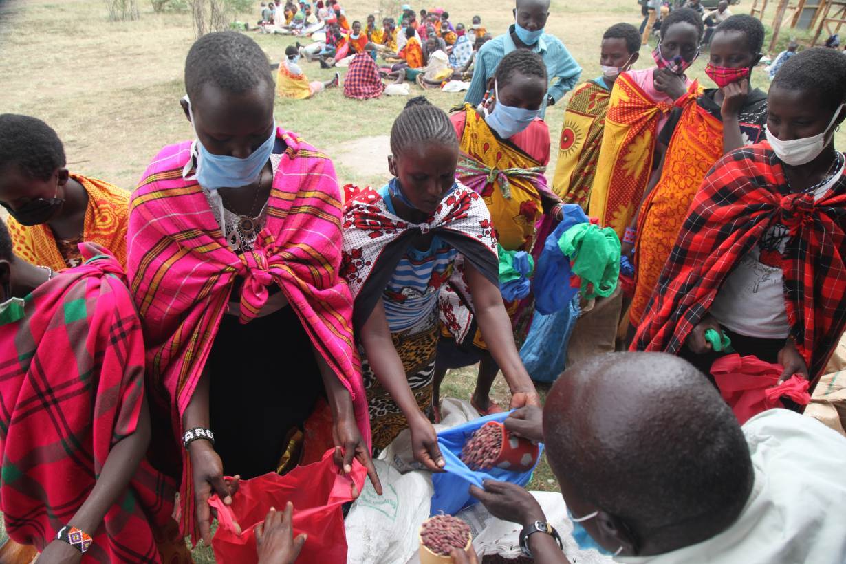 Community elders distribute food aid at Nashulai Maasai Conservancy, located near the Maasai Mara National Reserve in Narok county, Kenya on July 14, 2020. | THOMSON REUTERS FOUNDATION/Nita Bhalla