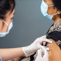 A healthcare worker vaccinates an elderly person. | iStock via Getty Images