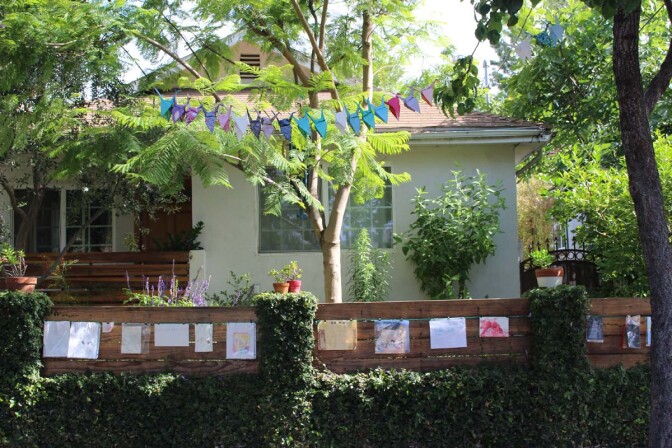 Dan Fields’ Los Feliz fence gallery features children's artwork hanging from a cable.