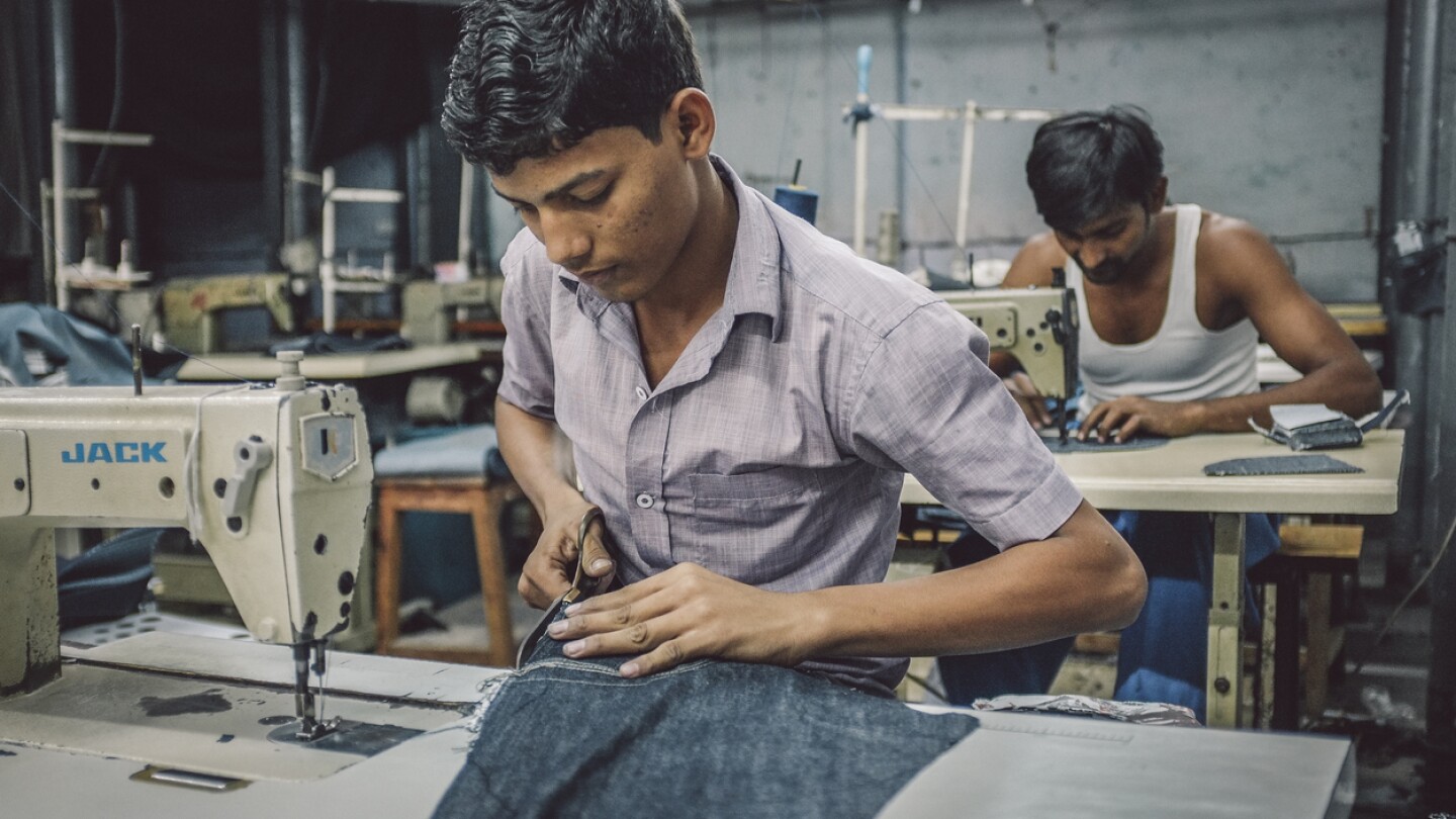 Indian workers sew in clothing factory in Dharavi slum