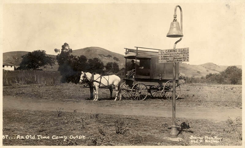 A wagon an an El Camino Real mission bell west of the San Fernando Valley, circa 1920
