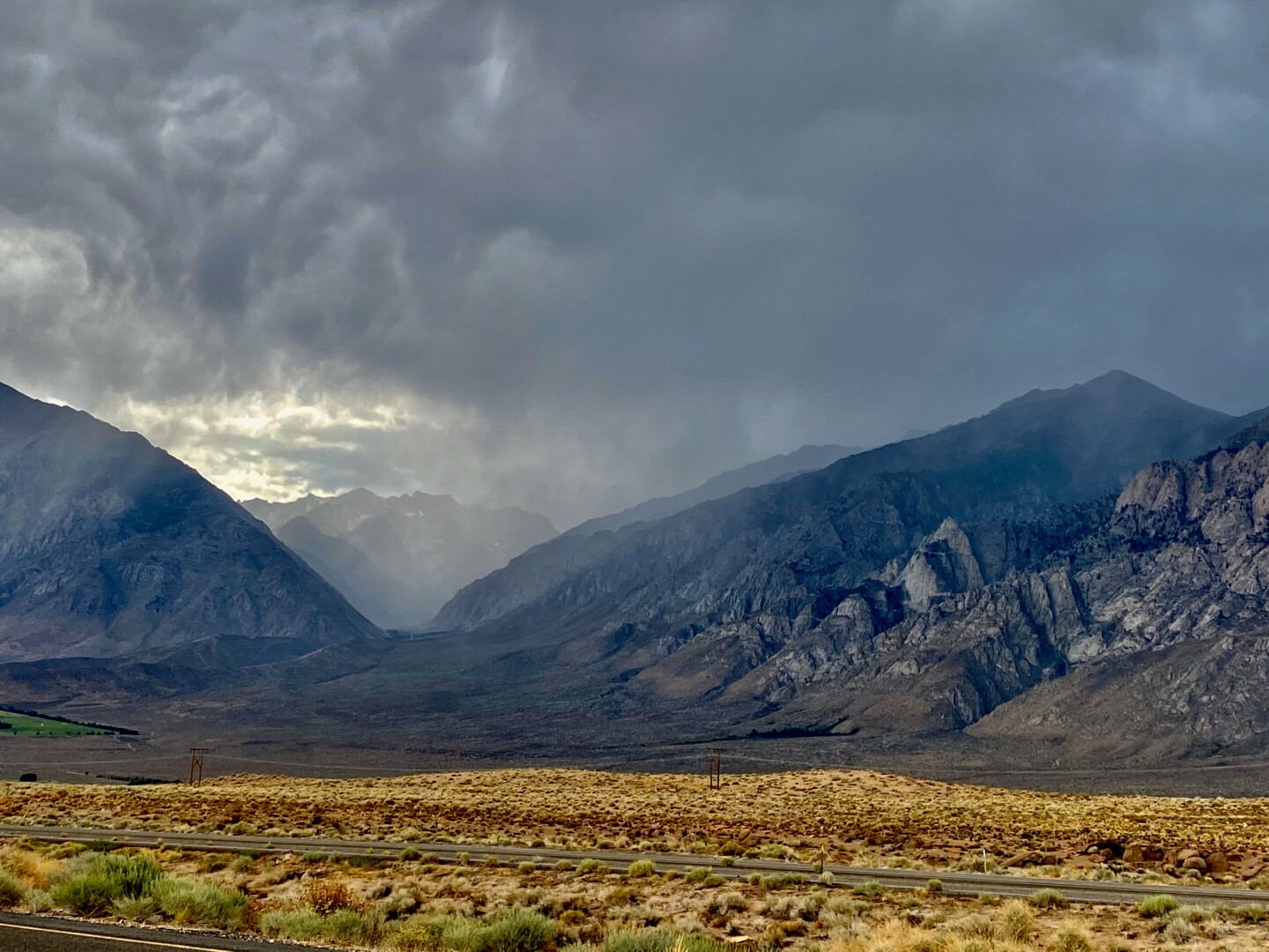 Rain falling over the Sierra mountains as viewed from the highway