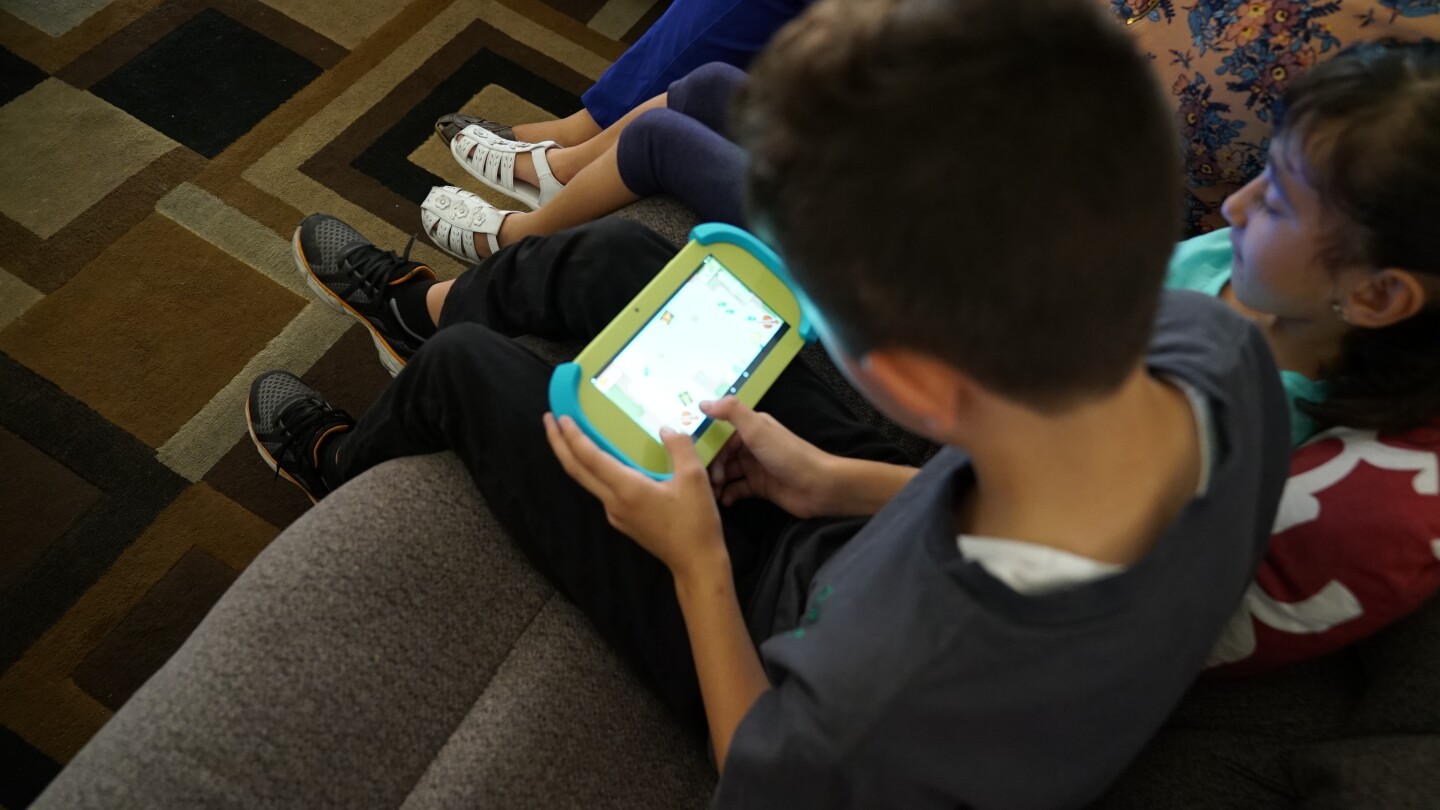 A young boy and young girl using educational tablets.