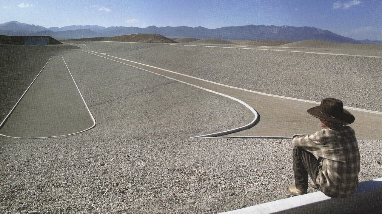 Michael Heizer sits on the ledge of one of his City installations.