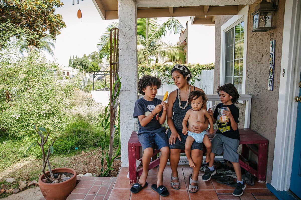 Panquetzani sits with her children on a porch. | Samanta Helou Hernandez