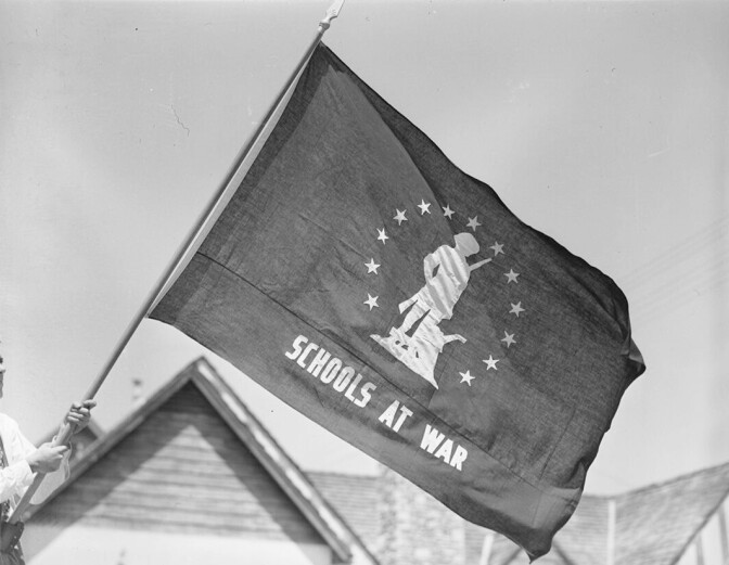 Flag that says schools at war. The flag that awarded to schools that met war bond sales goals.