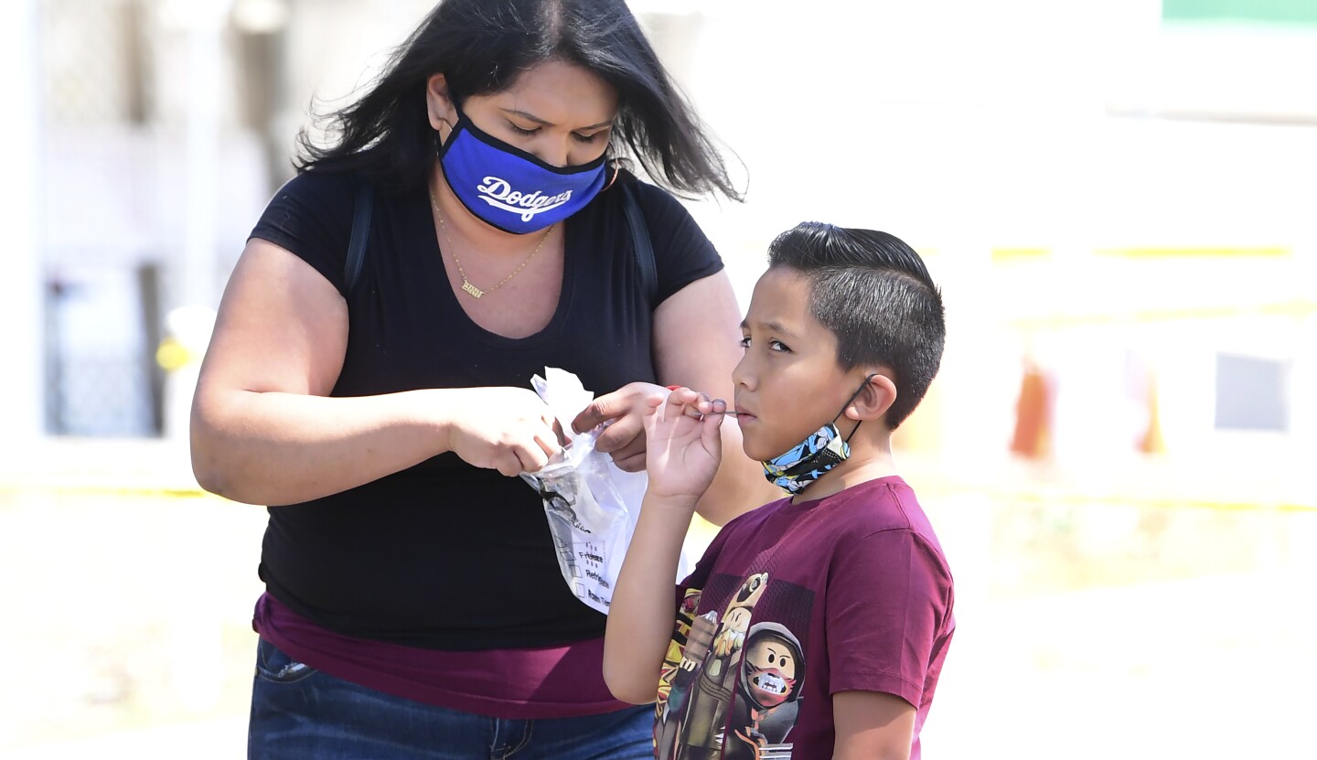 A child takes a COVID-19 test at a walk-in COVID-19 test site in Los Angeles, California on July 17, 2020.
