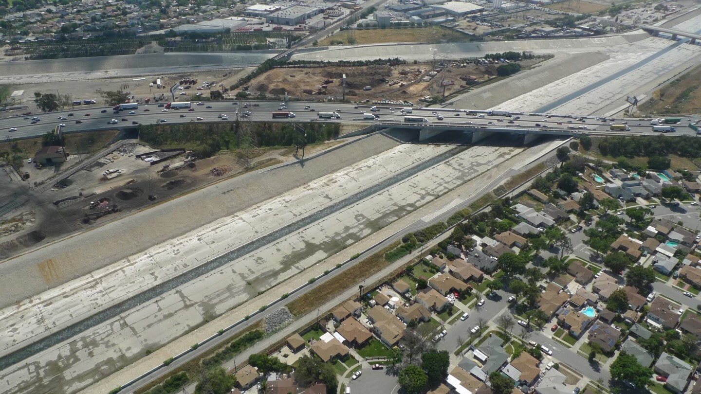 A freeway crosses a concretized river bed. This is an aerial view of the Los Angeles River as it meets the Rio Hondo.