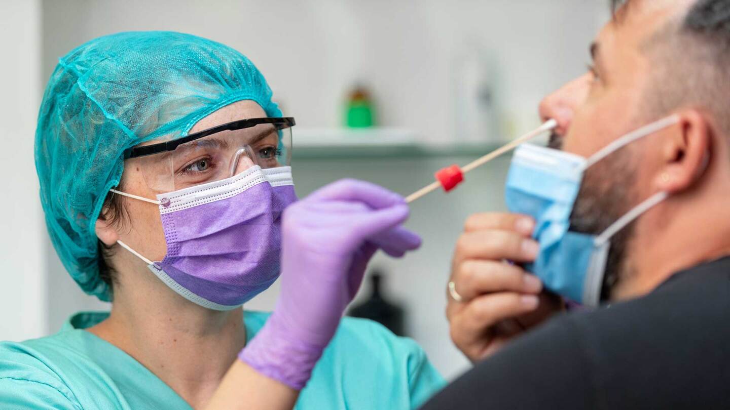 A medical worker administers a COVID-19 test on an individual.
