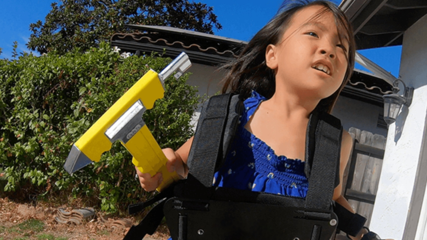 A young child holds a tool as she participates in the "What a Disaster!" game show.