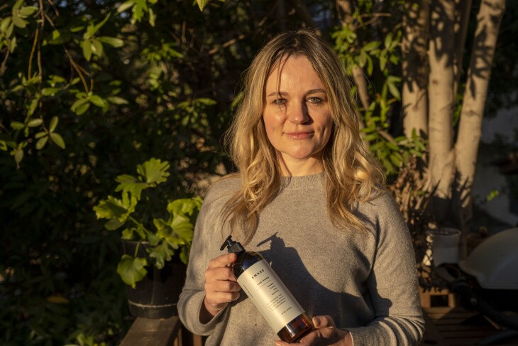 Morgan McLachlan holding a bottle of sanitizer she developed for Amass. | Chava Sanchez/LAist