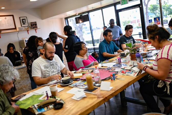 Participants make zines at a zine-making pop-up at Patria Coffee in 2018.