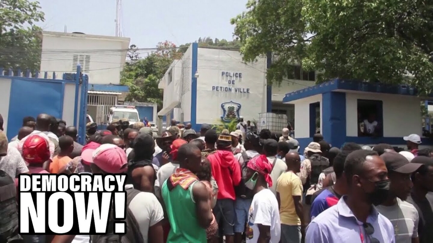 A crowd of people gather outside a police station in Haiti.